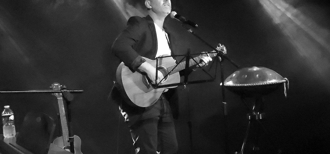 Sur scène, guitare et voix